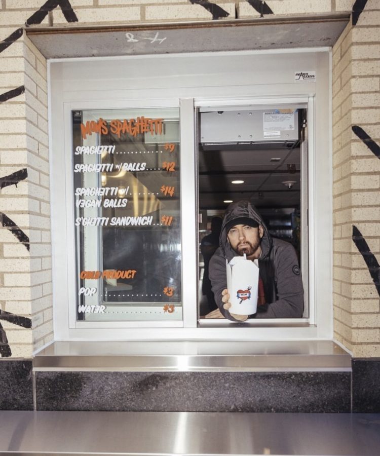 Eminem leans out of the window of his Detroit pop up restaurant Moms Spaghetti 