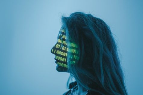 A visualization of a woman with computer code projected across her face to represent AI, or artificial intelligence.