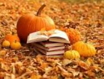 Stack of books surrounded by leaves and pumpkins